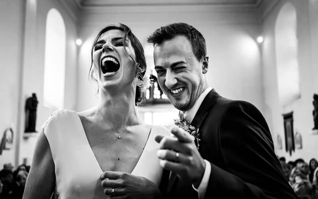 Un couple éclaté de rire face à un photographe de mariage à Paris